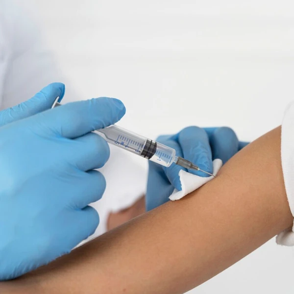 Doctor administering a hay fever treatment injection to a patient's arm.